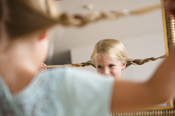 Girl (6-7) reflecting in mirror