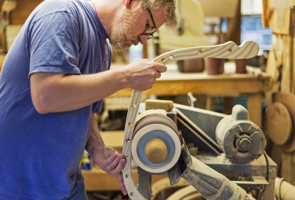Carpenter polishing wood with sander