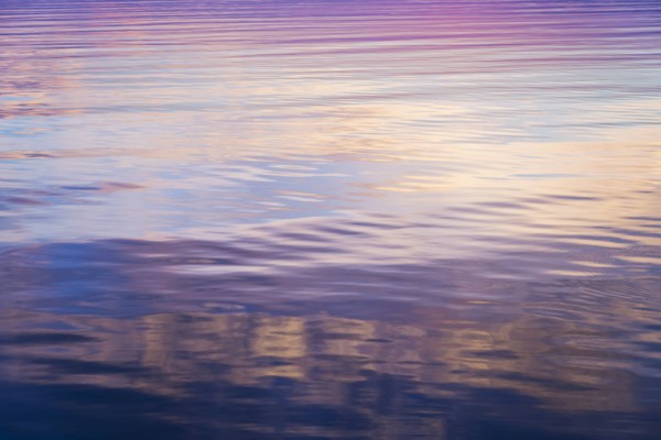 Rippled water reflecting colorful light