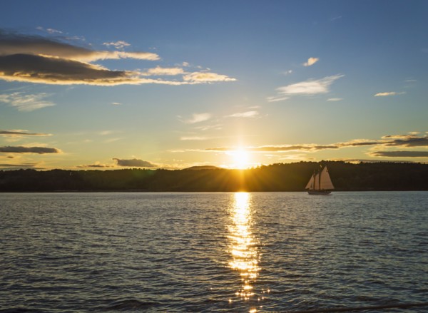 Tranquil seascape with sailboat at sunrise