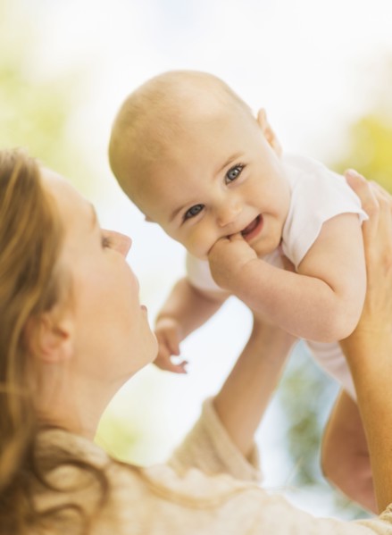 Mother holding up baby boy (6-11 months)
