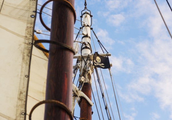 Close-up of sailboat's mast and pirate flag