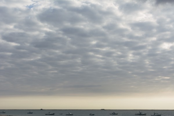 Cloudscape above sea with boats