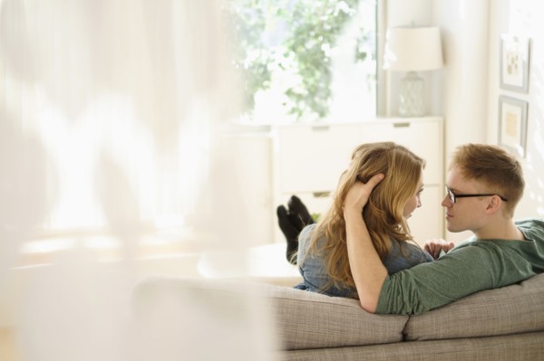 Young couple sitting face to face on sofa.