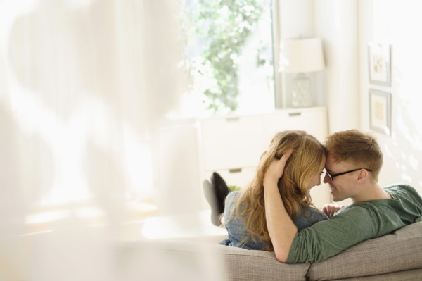 Young couple sitting face to face on sofa.