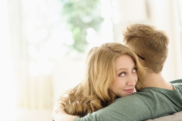 Young woman looking over boyfriend's shoulder.