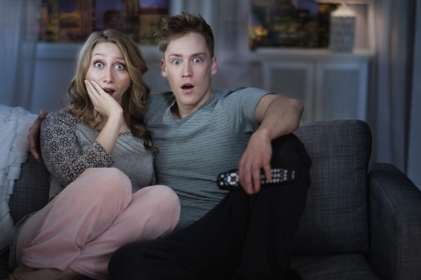 Young couple watching TV at night.