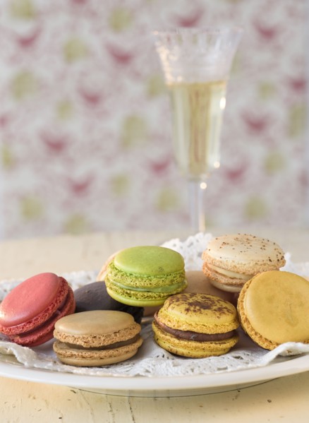 Macaroons on plate with champagne in background.