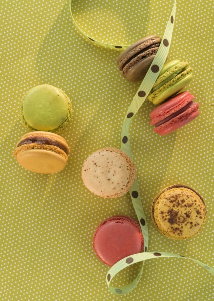 Macaroons on green tablecloth.
