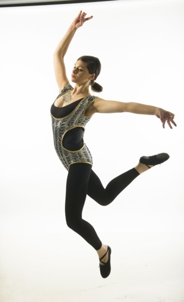 Young woman jumping on black background.