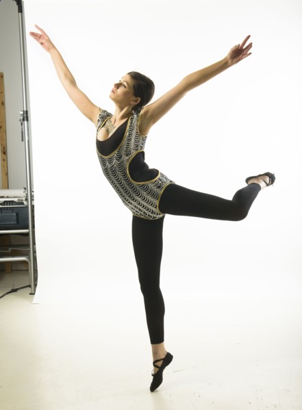 Young woman dancing against white background.