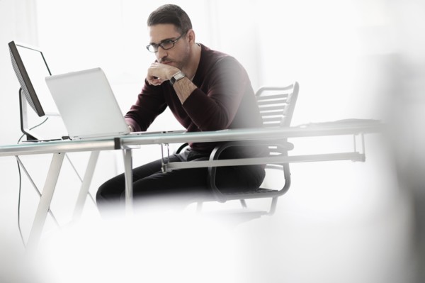 Man using laptop in office.