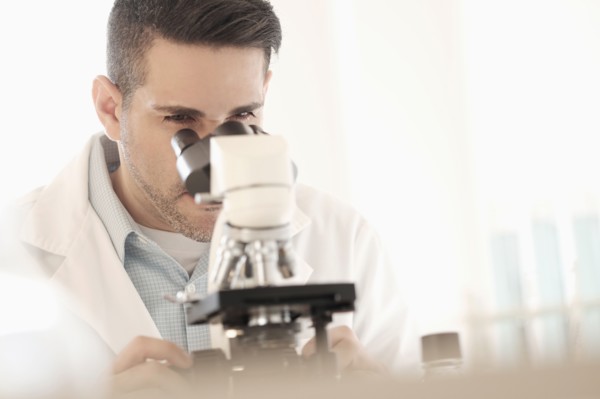 Man looking through microscope.