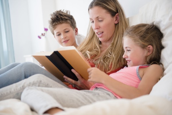 Mother reading with daughter (6-7) and son (8-9)