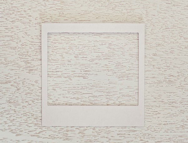 Empty Polaroid frame on textured wood