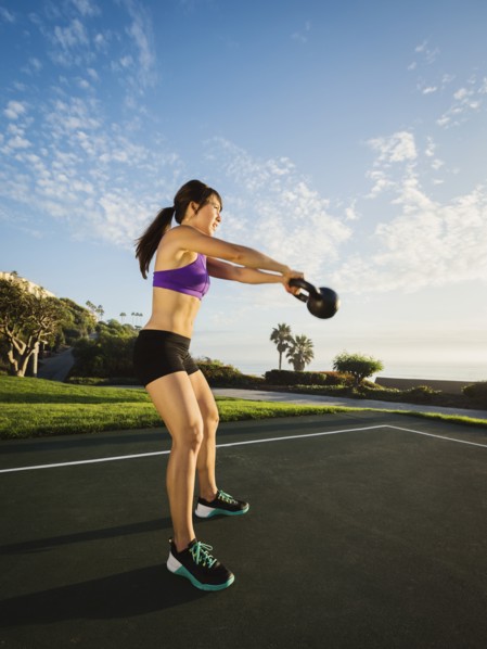 Young woman exercising with kettlebell