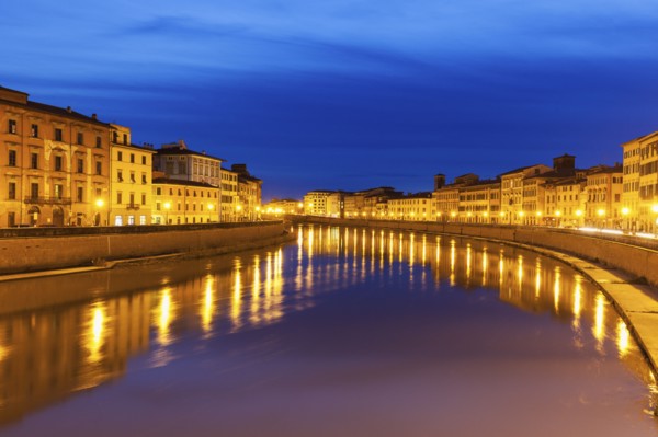 Illuminated townhouses by Arno river at night