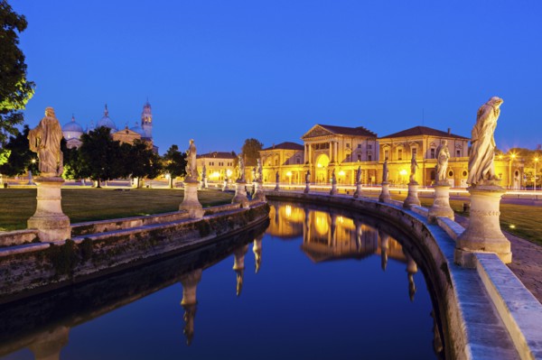 Illuminated Prato della Valle with statues at dusk