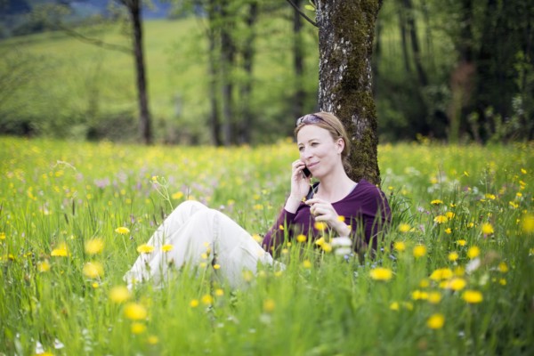 Woman talking on phone in meadow