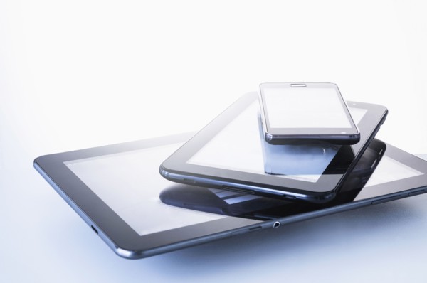 Smart phone lying on digital tablets.