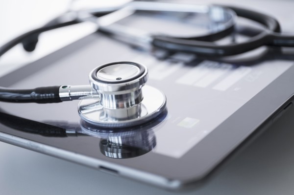 Stethoscope lying on digital tablet.