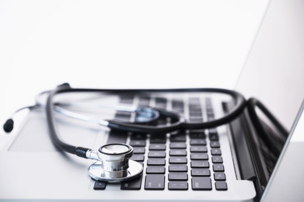 Stethoscope lying on laptop.