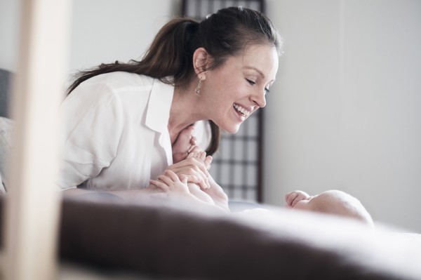 Mother playing with baby daughter (2-5 months).