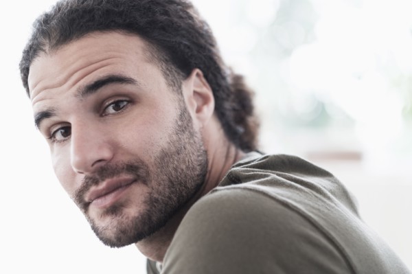 Portrait of young man with long curly hair.