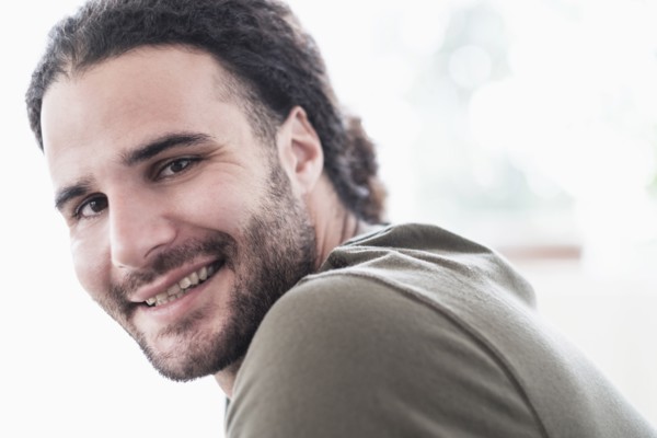 Portrait of young man with long curly hair.