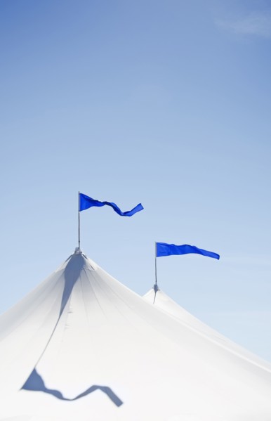 White tents with blue flags at county fair
