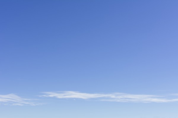 Clear blue sky with scattered clouds