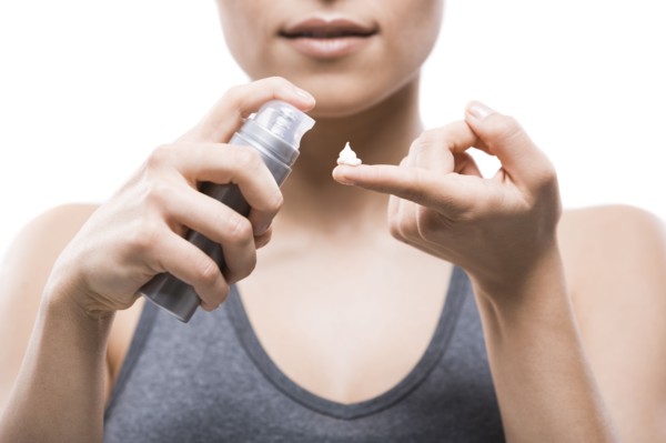 Young woman applying moisturizer