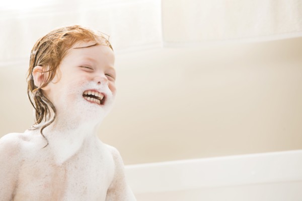 Smiling girl (4-5) having bubble bath
