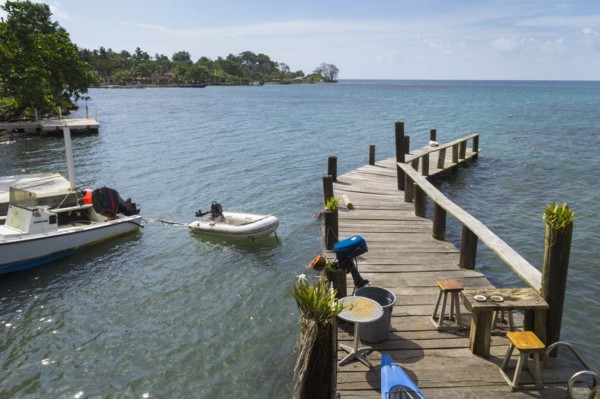 Wooden jetty with motor boat nearby on sea