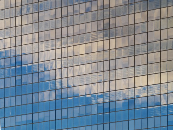 Sunlight and clouds reflecting in windows of office building