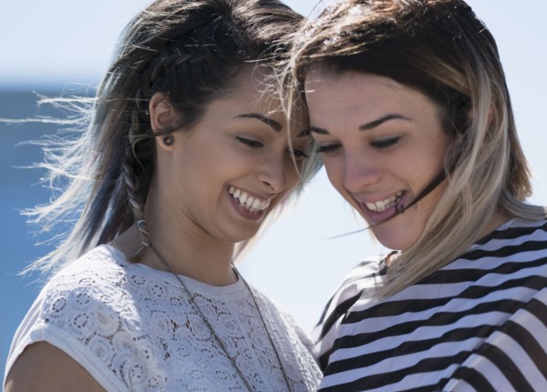 Smiling young women looking down.