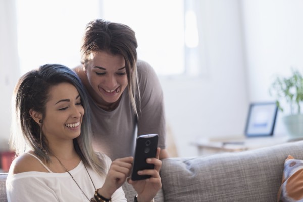 Young women using mobile phone at home.