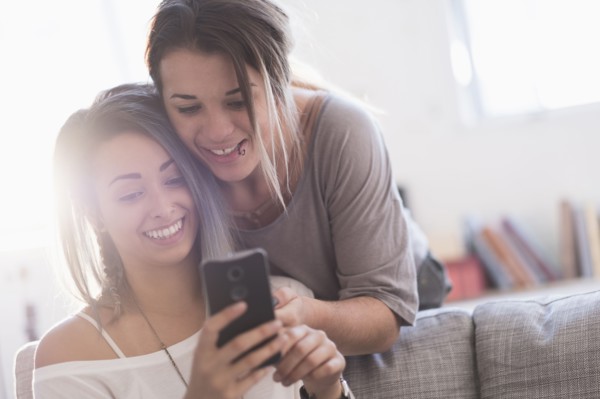 Young women using mobile phone at home.