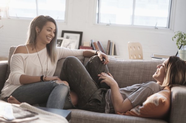 Young women talking on sofa.