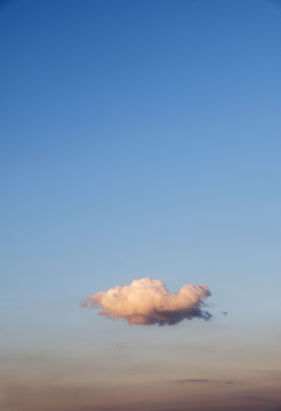 Single cloud on blue sky at sunset.