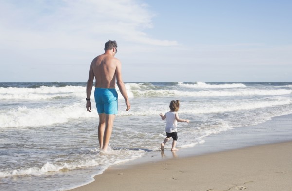 Father with daughter (18-23 months) walking on beach