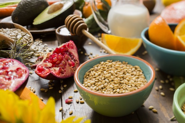Wheat seeds in bowl and fresh fruits