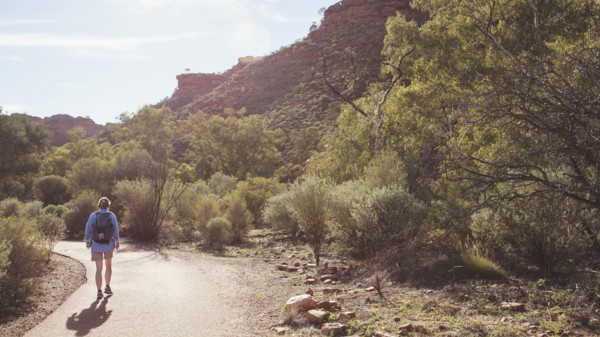 Australia, Outback, Northern Territory, Red Centre, West Macdonnel Ranges, Kings Canyon, Woman walking down mountain road