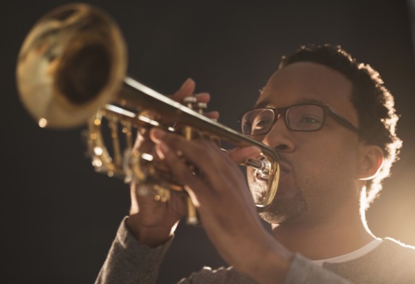 Mid adult man playing trumpet.