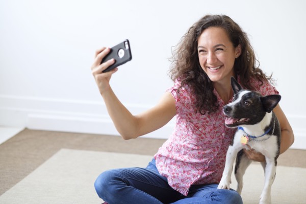 Young woman taking selfie with her dog.