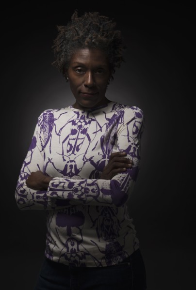 Studio shot of woman standing with arms crossed.