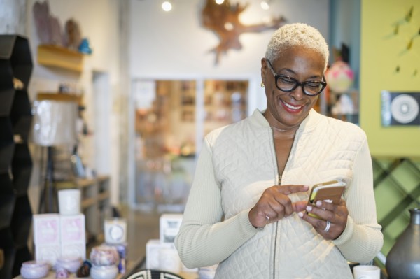 Woman using mobile phone in shop.