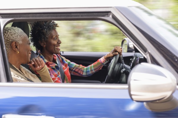 Two smiling women in car.