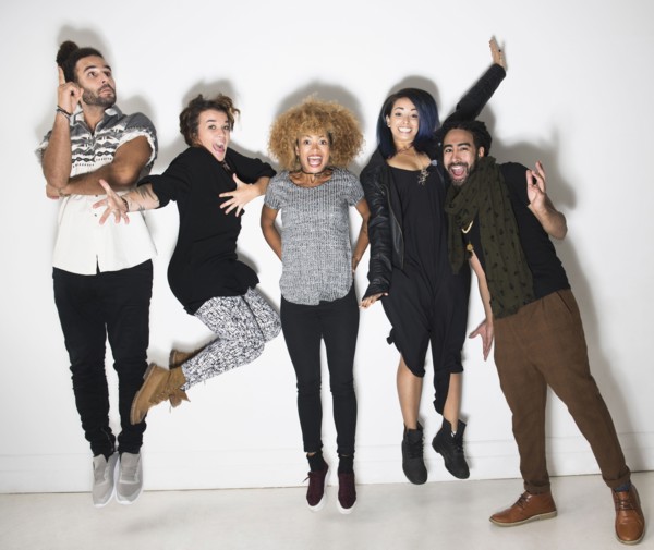 Portrait of group of happy friends against white wall.