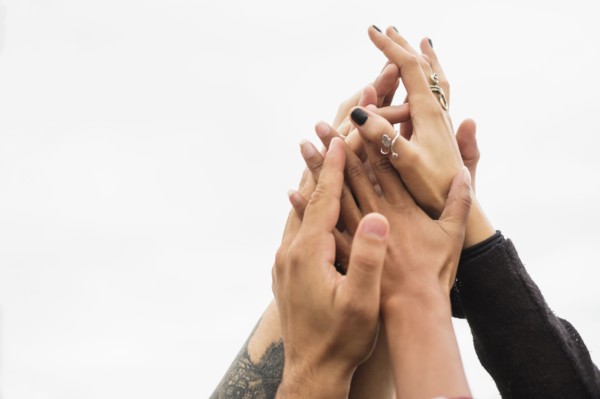 Friends holding their hands together.